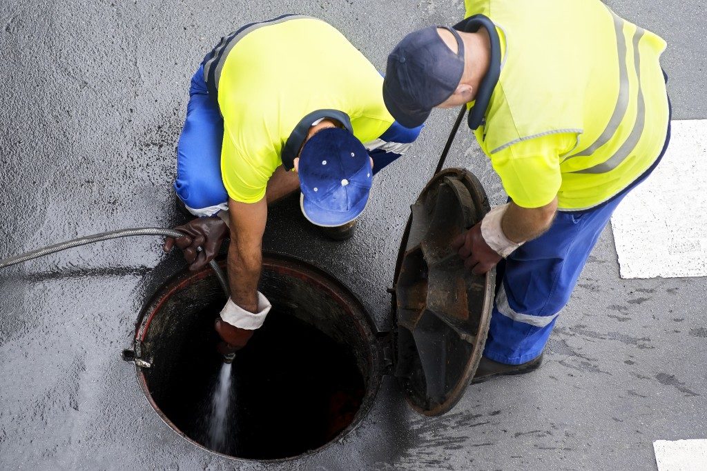 men cleaning sewer system