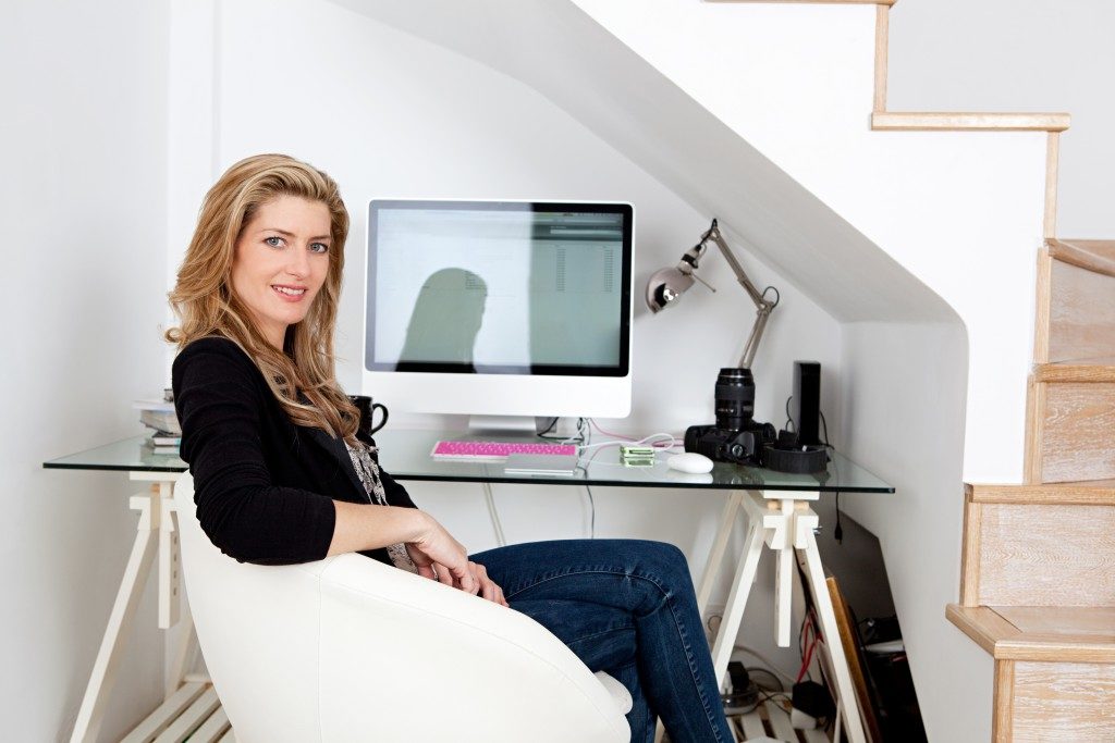 professional photographer working from home and sitting at her desk at home, with her camera equipment