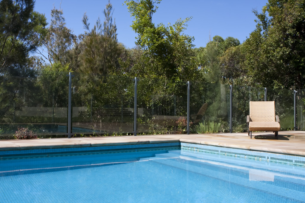 A luxury outdoor pool with deck chair beside it