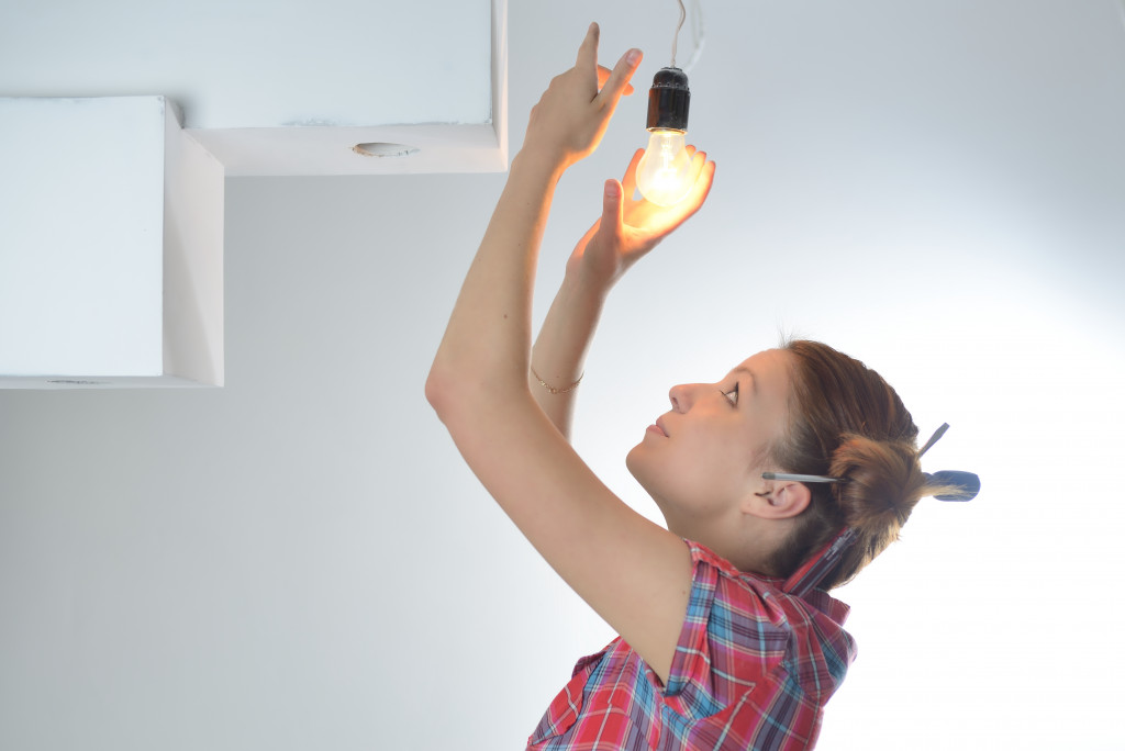 woman changing the lightbulb