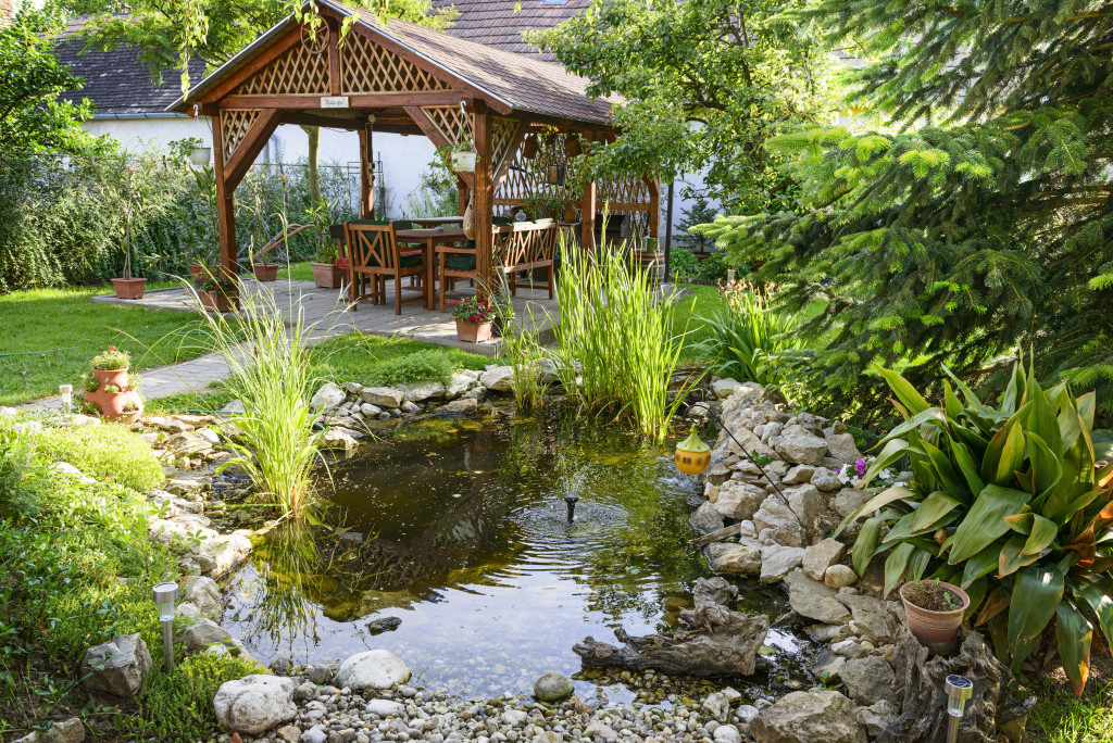 A backyard garden with a pond and a gazebo