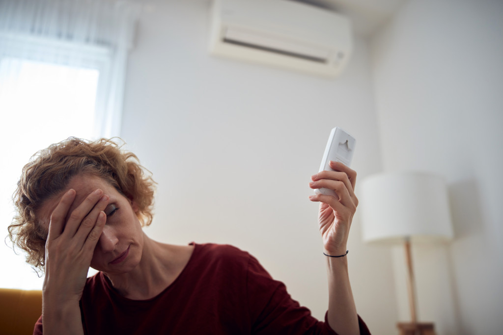 woman turning on the air conditioning