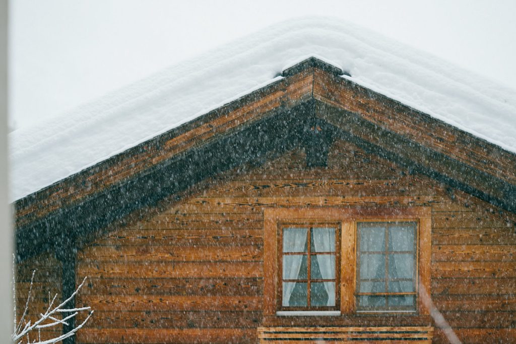 House with roof piled with snow