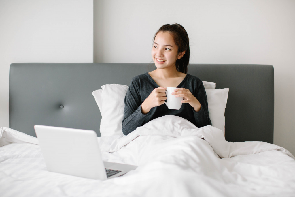 woman comfortably sitting on her bed