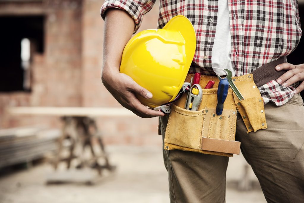 a man holding construction gear helmet