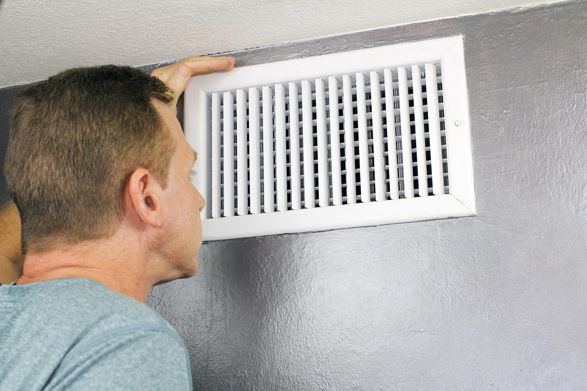 guy looking into a home air duct