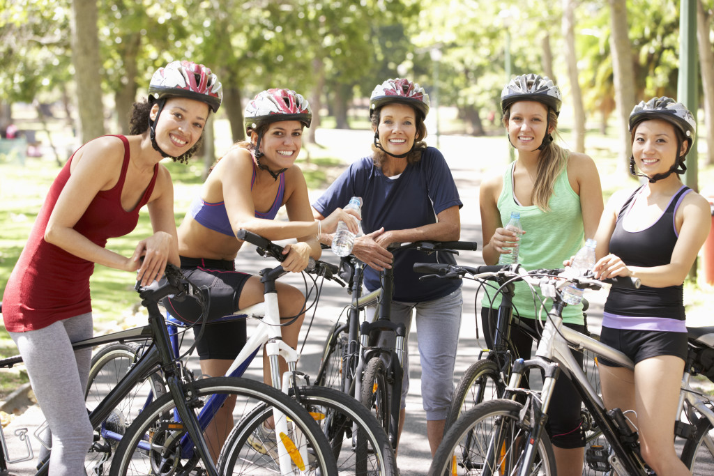 Group of women taking a break from biking at a park.