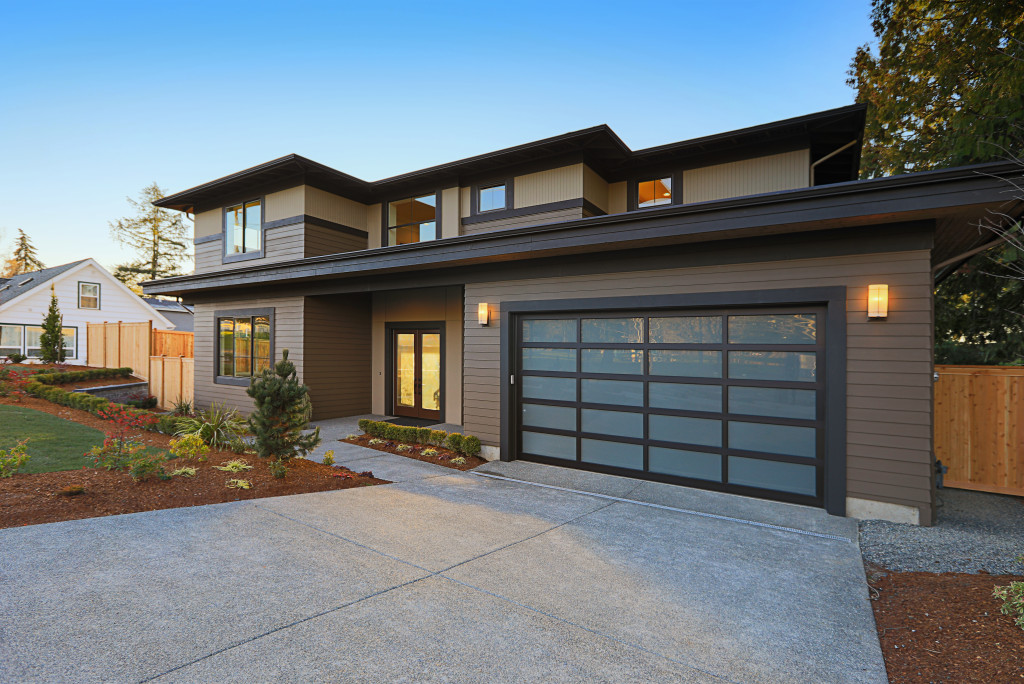 Curb appeal of a modern house with a wide driveway and suitable lawn.
